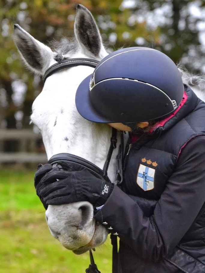 Enfant faisant un calin à son poney en portant des gants d'équitation pour sa sécurité